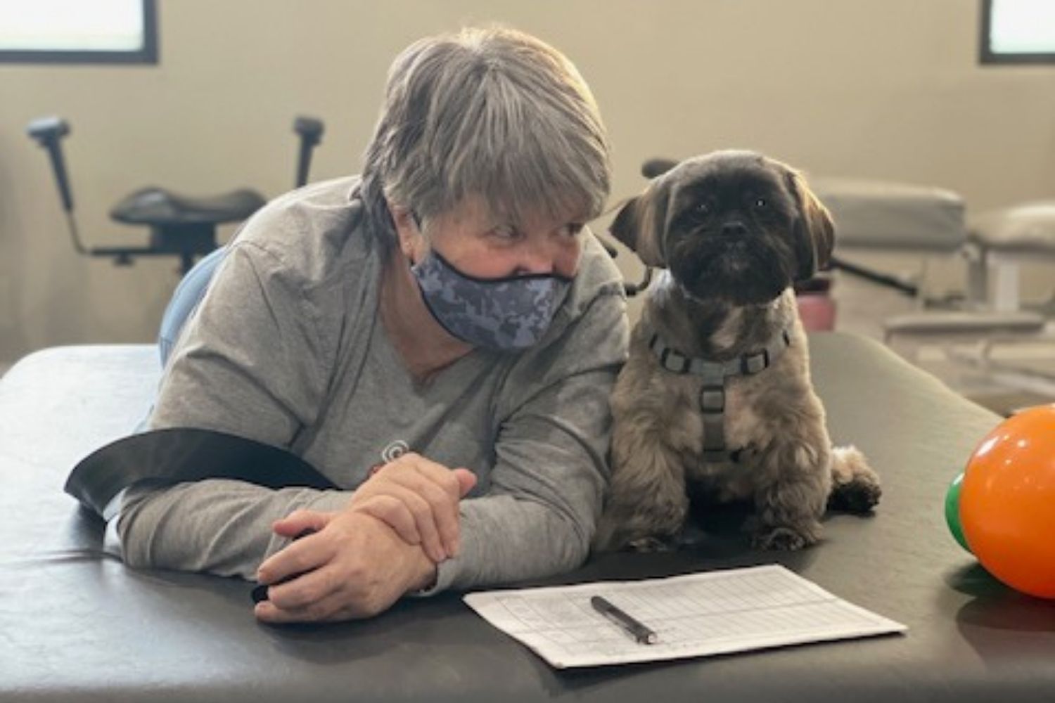 Therapist assisting patient with dog